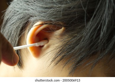 Close Up Removing Ear Wax Using A Cotton Bud In Child.