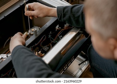 Close up of repairman with screwdriver fixing coffee machine at table indoors - Powered by Shutterstock