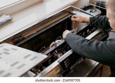 Close up of repairman with screwdriver fixing coffee machine at table indoors - Powered by Shutterstock