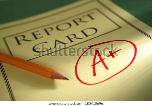close up of report\
card with A+ and pencil 
