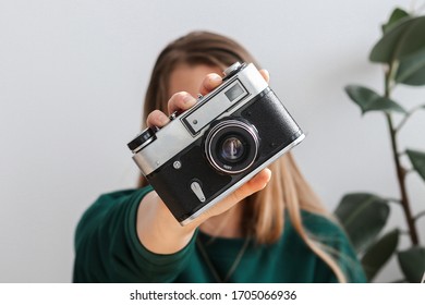 Close up to the retro analog camera held by blond girl