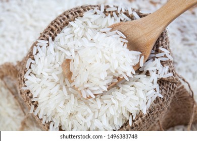 Close up the rice on wood spoon put on the rice sack with blurry of pile rice - Shutterstock ID 1496383748