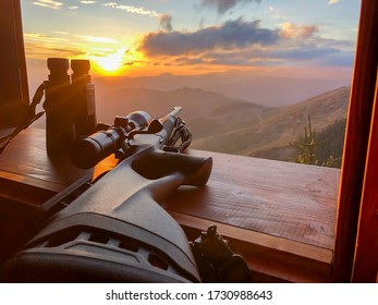 Close up of rifle and binocular for  hunting. View from the window on sunrise. - Shutterstock ID 1730988643
