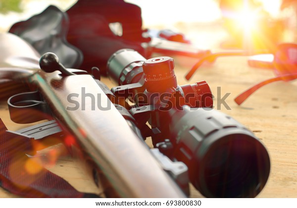 close up of rifle telescope for sport hunting on table\
wooden 