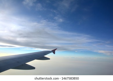 Close Up Of The Right Wings Of An Airplane, Aeroplane, Aircraft Flying In The Evening With Blue Sky And Some Scattered Clouds, Cumulus Humilis, Simpsons Clouds Hiding The Sun, Selective Focusing