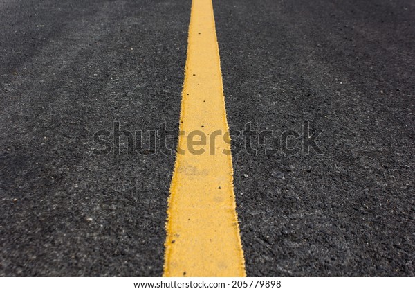 Close up road divide yellow\
line.