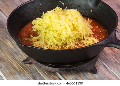 Close Up Of Roasted Spaghetti Squash With Marinara Sauce In Iron Pan.