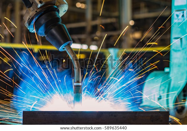 Close up robot welding in\
car factory