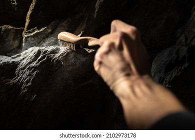 Close Up Of Rock Climber's Hand Brushing A Hold With Chalk On It On A Boulder (climbing Outdoors) With Powder Falling