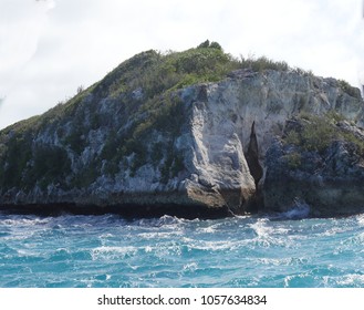 Close Up Of A Rocky Island With Small Waves Crashing Against The Edge At Thunderball Grotto, Exuma Cays, Bahamas. The Site Is Popular For Tourists And Has Been A Location For Several Movies.