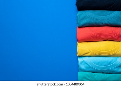 close up of rolled colorful clothes on blue background
