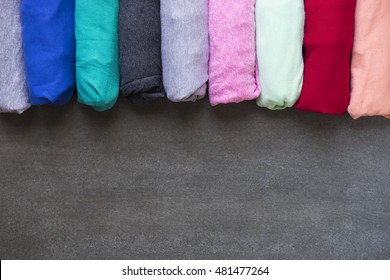 close up of rolled colorful clothes on black background