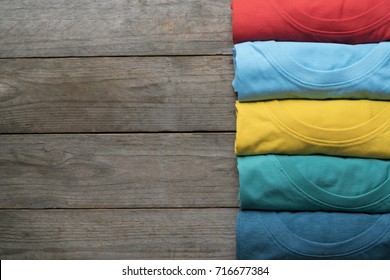 close up of rolled colorful clothes on wood table background