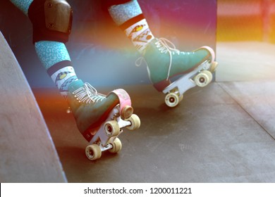 Close up of roller skates at on a skater sitting on a ramp at the skate park, photo filtered to have a rainbow vintage look - Shutterstock ID 1200011221