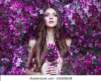 Close up romantic portrait of beautiful elegant woman in blossom spring trees.