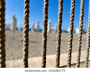 A close up Rope on the beach. Rope with blur background with blue sea and sand. Focus on the rope. - Powered by Shutterstock