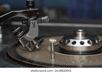 Close up of a round diamond in the process of being cut by a cutter machine. 