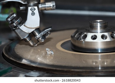Close up of a round diamond in the process of being cut by a cutter machine. 