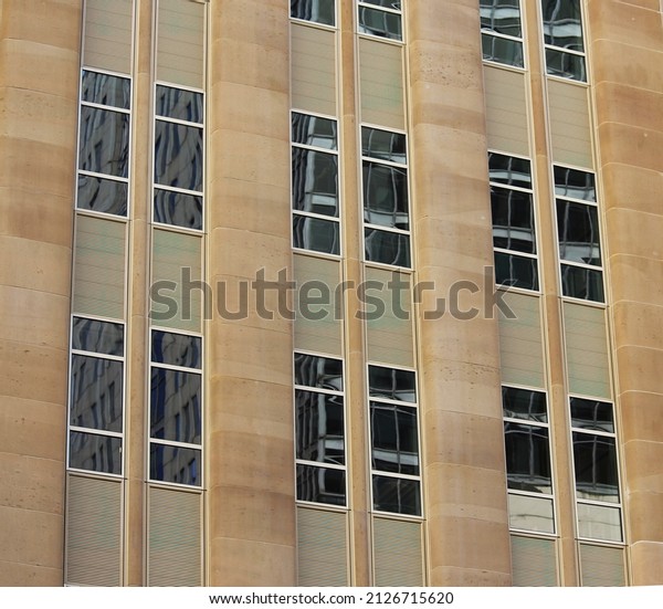 Close up of rounded sandstone panels and windows\
on an old office building