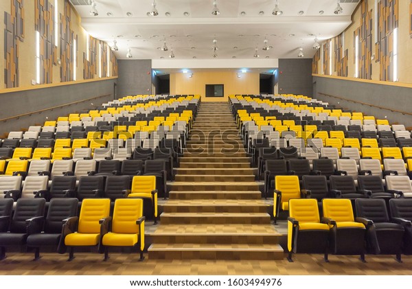 Close Up row of modern\
designed indoor seats in the theater., Modern interior of school\
assembly hall.