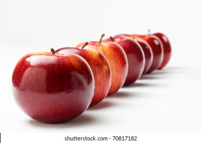 Close Up Of A Row Of Seven Shiny Red Apples Leading Away From The Viewer At An Oblique Apple.