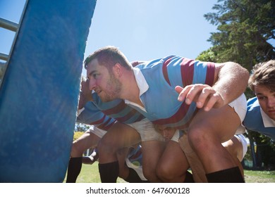 Close up of rugby players crouching at field on sunny day - Powered by Shutterstock