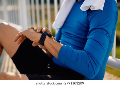 Close up of runner checking heart rate on smart watch outdoors.