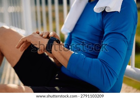 Close up of runner checking heart rate on smart watch outdoors.