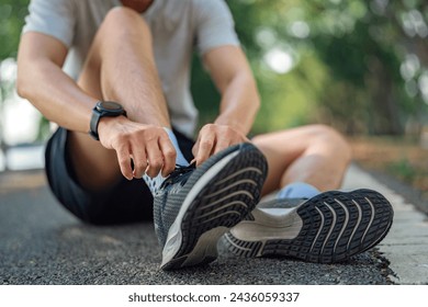 Close up - Running shoes runner man tying laces for summer run in forest park. Jogging girl exercise motivation health and fitness exercise. - Powered by Shutterstock