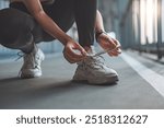 Close up - Running shoes runner woman tying laces sneakers for summer run in the city. Jogging girl exercise motivation health and fitness exercise, lifestyle.