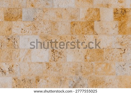 Close up of a rustic limestone brick wall texture from Cagliari, Sardinia, featuring natural rough masonry and stone surface