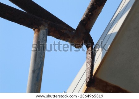 close up of a rusting iron structure against a blue sky background in the early morning sunshine