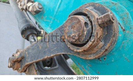 A close up of a rusty bolt and hinge mechanism