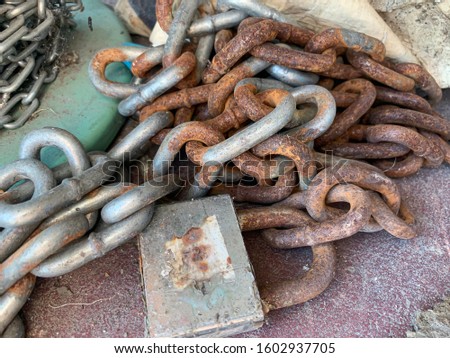 Close up of rusty chain and lock put on the ground
