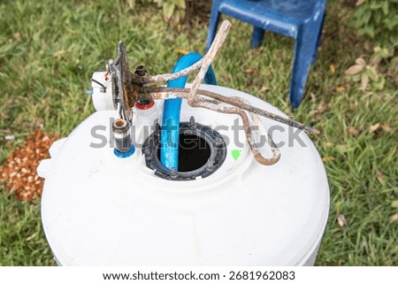 Close up of rusty electric heating element with scale removed from water heater tank. Household appliance repair, corrosion, cleaning and limescale buildup concept.