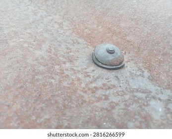 close up of rusty roofting screw with rubber washer on corrugated metal sheet. construction hardware and building material texture.
