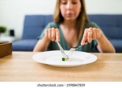 Close Up Of A Sad Adult Woman With No Appetite At Home While Trying To Eat Despite Her Bad Mental Health And Eating Disorder