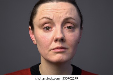 Close Up Sad Adult Woman's Face Against Gray Background 