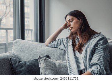 Close up of sad pensive millennial woman sit alone thinking about relationships personal problems, upset thoughtful young female lost in thoughts feel lonely depressed pondering or mourning at home - Powered by Shutterstock