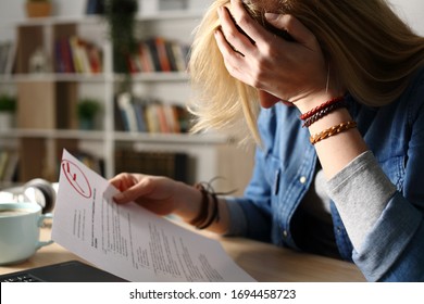 Close up of sad student complaining about failed exam sitting on a desk at home at night