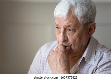 Close up of sad thoughtful old grandfather look in distance feel lonely and depressed, upset pensive mournful senior man husband thinking pondering missing passed wife, elderly solitude concept - Powered by Shutterstock