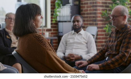 Close Up Of Sad Woman Making Confession About Therapy And Addiction At Aa Meeting In Circle. Adult In Despair Having Discussion About Alcoholism With People And Psychotherapist.