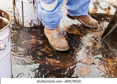 Close Up Safety Boot. Worker Cleaning Crude Oil Contaminated On Floor. Waste Management