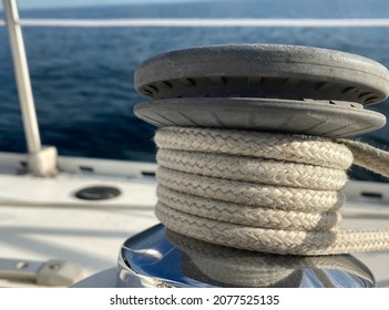 Close Up Of Sailboat Winch With Jib Sheet Wrapped Around It On A Sunny Day.