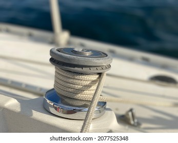 Close Up Of Sailboat Winch With Jib Sheet Wrapped Around It On A Sunny Day.