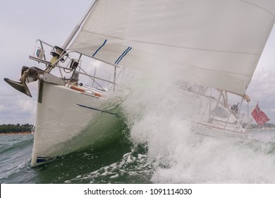 Close Up Of Sailing Boat, Sail Boat Or Yacht Crashing Through Waves In A Rough Sea