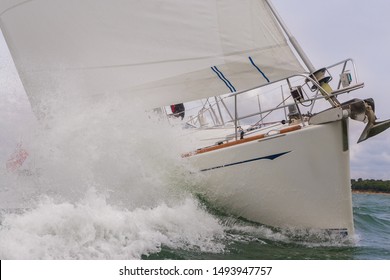 Close Up Of Sailing Boat, Sail Boat Or Yacht Crashing Through Waves In A Rough Sea