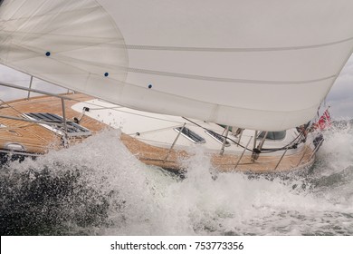 Close Up Of Sailing Boat, Sail Boat Or Yacht Crashing Through Waves In A Rough Sea