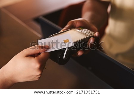 Close In Of Sales Assistant In Retail Shop With Customer Paying Using Contactless Payment Credit Card NFC