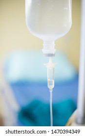 Close Up The Saline Solution Bottle And Blurry Hospital Bed And Blurbackground.